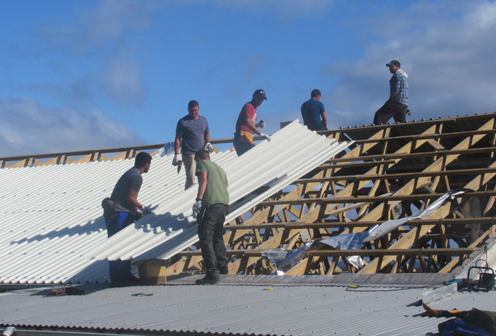A new roofing sheet being moved into place