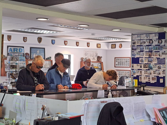 Crew writing postcards at the Post Office counter.