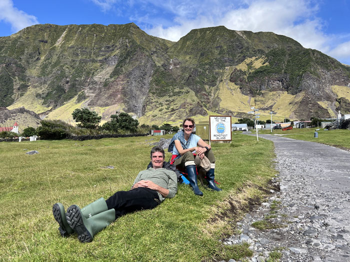 Visitors relaxing on the sward near the Remotest Island sign