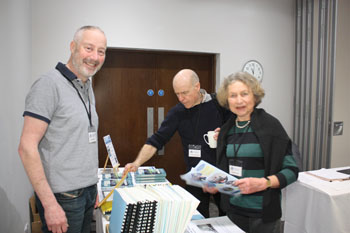 Clive Siddall serving Alasdair MacEachen and Gisela Lapot at the Tristan book stall