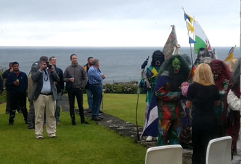 Okalolies greeting Marina with flowers, viewed from behind through window
