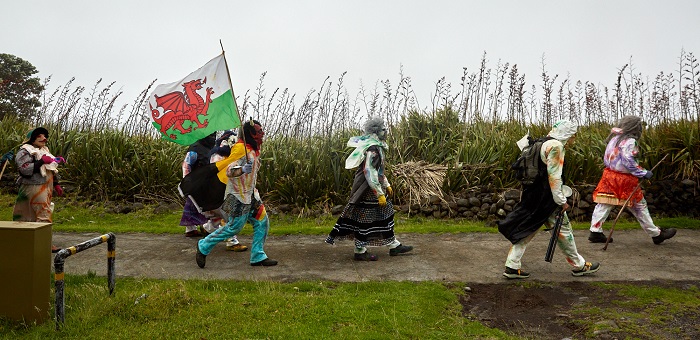 Six Okalolies striding along a road in the settlement