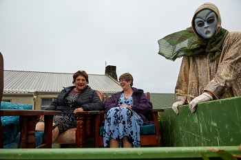 Felicity Glass and Louise Kendall in armchairs on a tractor trailer with one Okalolie