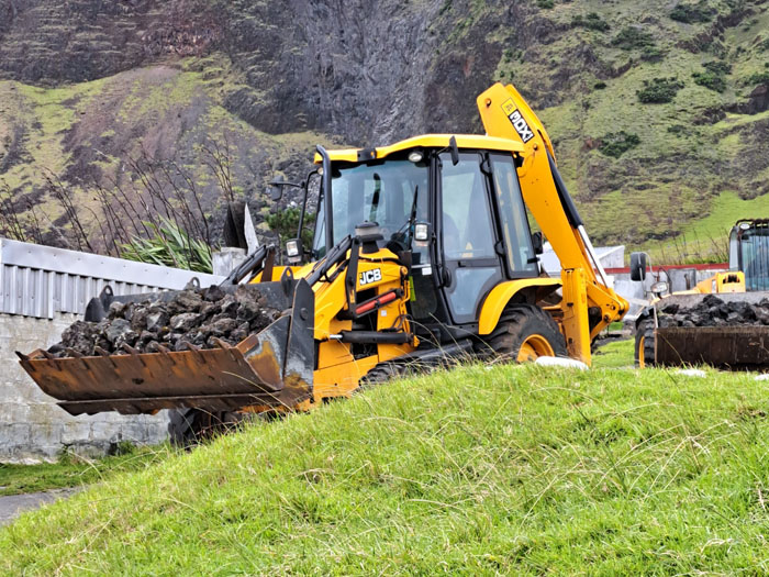 A JCB digger transporting lava stones from the 1961 volcano
