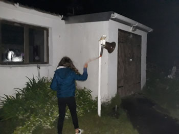 Amber Repetto ringing the bell outside the door of St Mary's Church