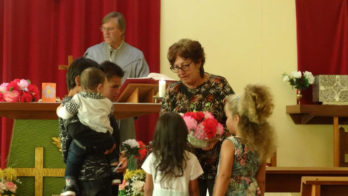 Children in St Joseph's Church collecting bunches of flowers to give to their mothers, grandmothers and aunts.
