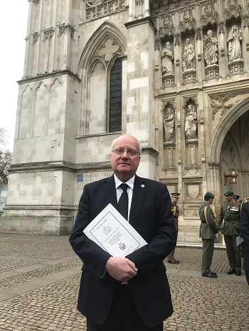 Chris Carnegy holding the order of service outside Westminster Abbey