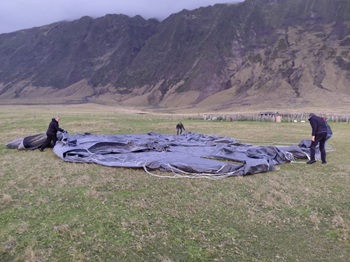 Islanders folding up one of the heavy load parachute Photo: Chloe Glass