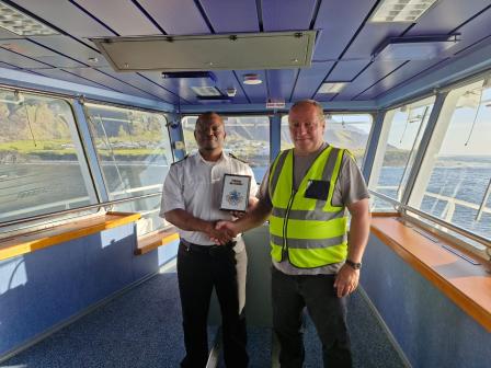 Ian Lavarello presenting a Tristan plaque to Captain Roland Clutties on the SA Agulhas II (Photo: Ian Lavarello)