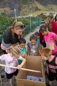 Children fishing for toys in a tub.