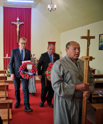 Another view of the 2025 Remembrance procession, led by Lay Minister Dereck Rogers with the Church cross.
