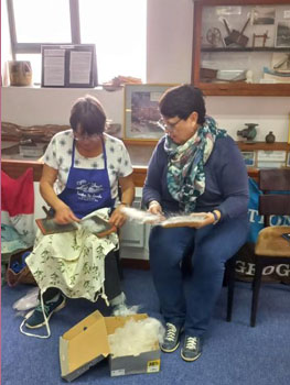 Linette Van der Merwe carding wool with Judy Green at the craft day