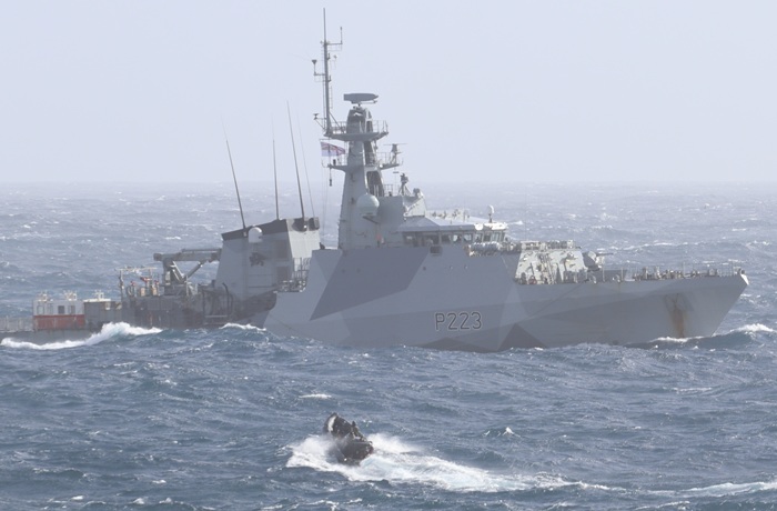 RIB struggling with rough seas as it approaches the starboard side.