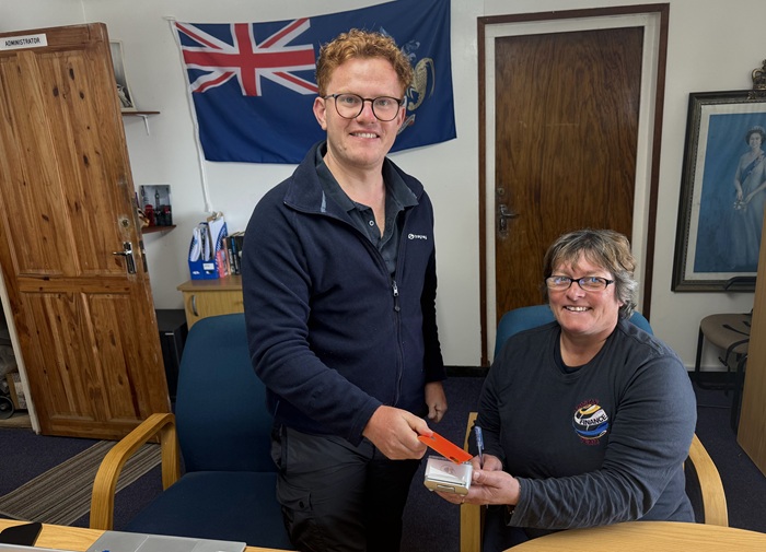 FCDO Desk Officer, Charles Wickham makes the first card payment on Tristan with Lorraine Repetto, Head of the Treasury Department