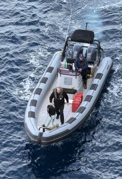 Our police Sergeant Barry Thacker arriving at the MV Silver Cloud, and evidently happy to have done stamping passports.