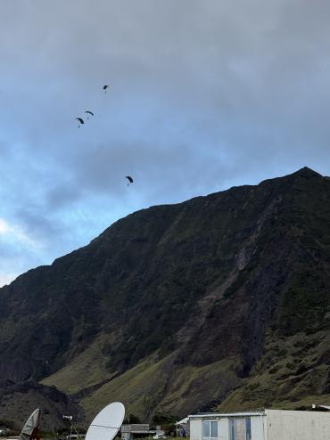 View from the ground as the paras appear above the cliffs. Photo: Philip Kendall