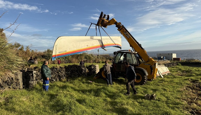 Using the telehandler to lift the windblown longboat Britannia off the Residency garden wall