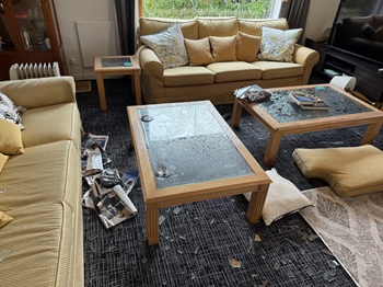 The main Residency living room, drenched and scattered with broken window glass.