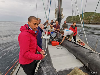 RSPB team preparing to launch the yacht's dinghy to go ashore.