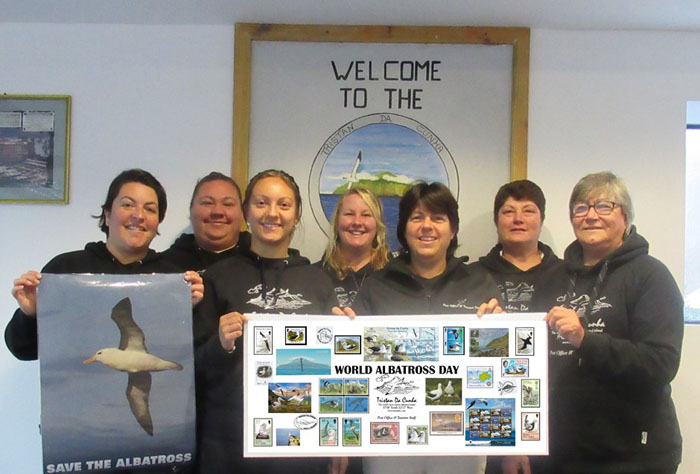 Post Office and Tourism staff holding their albatross poster