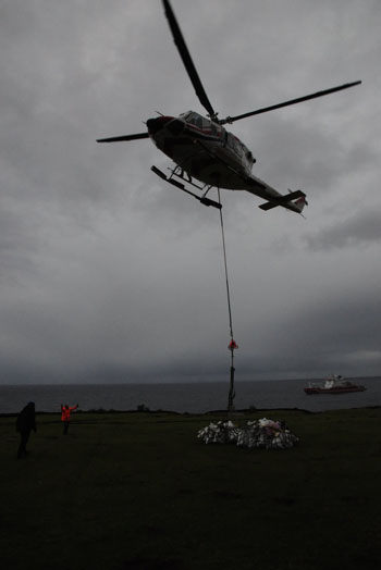 The helicopter lifts off with Tristan community's donations for Geo Searcher crew to the Agulhas II