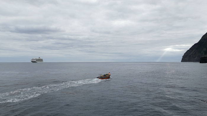 An island fishing boat passes in front of The World