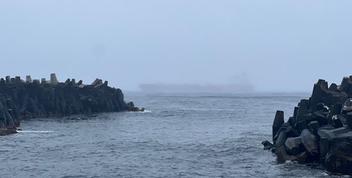 The tanker Donoussa off the harbour, just visible in the fog.