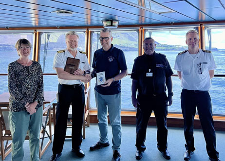 The Captain and Administrator Philip Kendall exchanging plaques on the ship's bridge