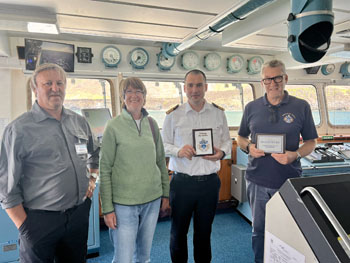 Seaventure Admin & Chief Islander exchanging plaques on the bridge