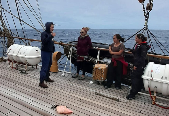 A crew member of the Bark Europa talking to Shirley Wainwright, and Chantelle and Katie Repetto