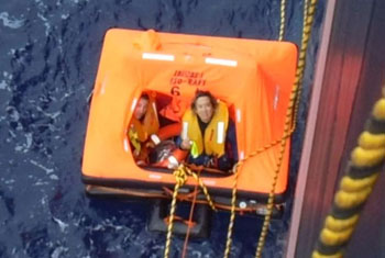 The survivors in their raft and climbing the ladders onto the tanker